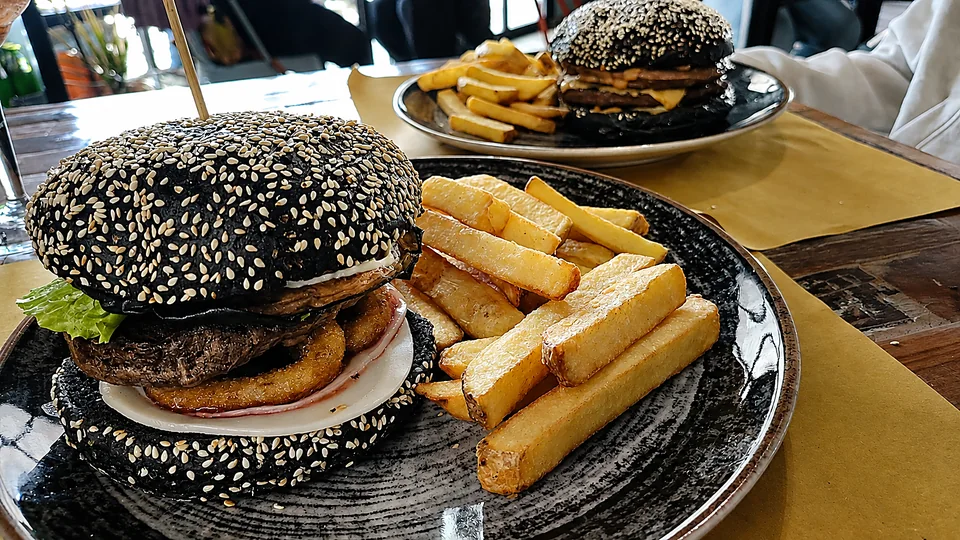Burger con pane nero al sesamo e patate fritte
